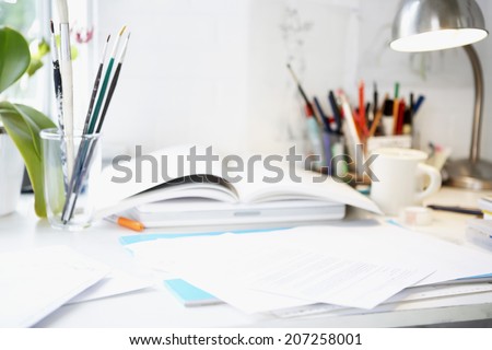 Artist\'s desk with books; papers and brushes