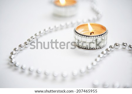 Closeup of lit tealight candles and silver garland