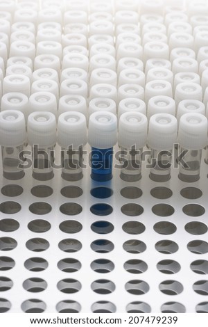 Blue test tube amongst empty test tubes