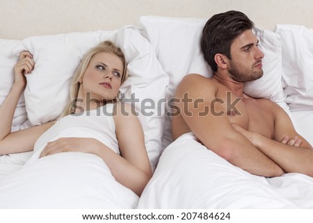 Young man ignoring woman in bed