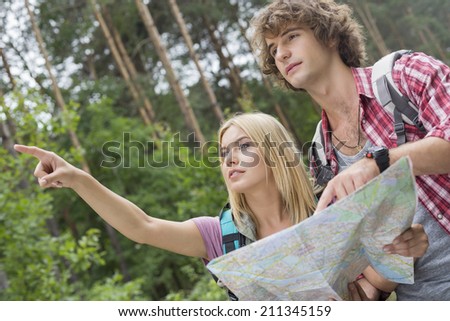 Hiking couple with map discussing over direction in forest