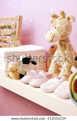 Stuffed toys, shoes and nappies on shelf in baby\'s room