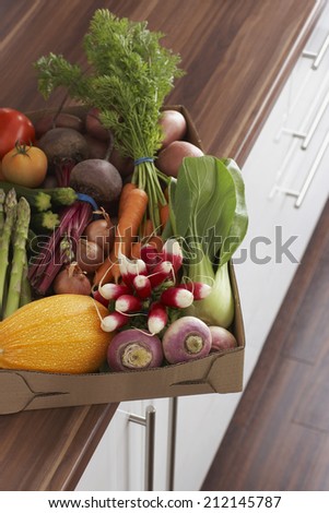 Container full of fresh vegetables on kitchen counter, close-up, elevated view