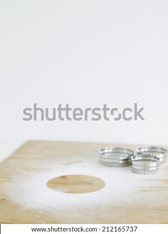 Pastry cutters and flour on table top, elevated view