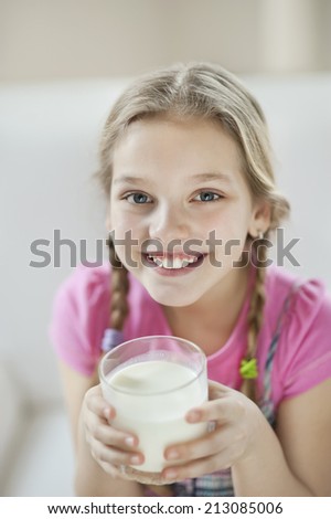 Portrait of happy young girl drinking milk