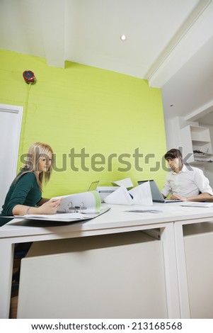 Side view of young businesspeople busy working at desk