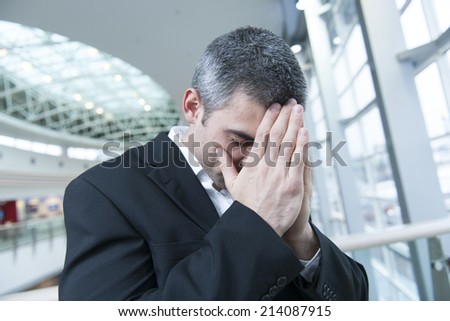 Disappointed businessman with head in hands