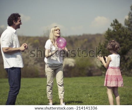 Family throwing ball to each other in the park