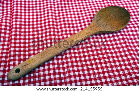 Wooden spoon close up on a red and white tablecloth