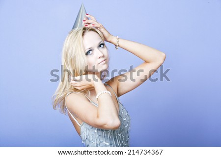 Sexy blonde party girl wearing silver dress and party hat