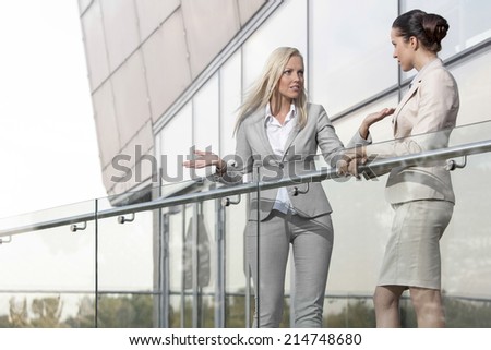 Young businesswoman arguing with female colleague at office balcony