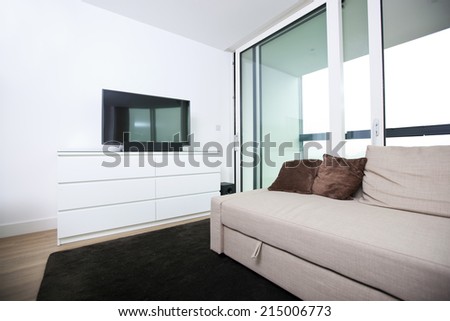 Living room with flat screen television in apartment