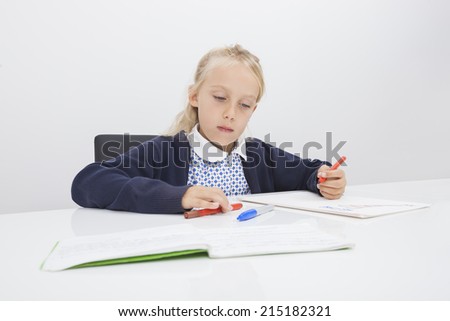Little girl drawing on paper at table