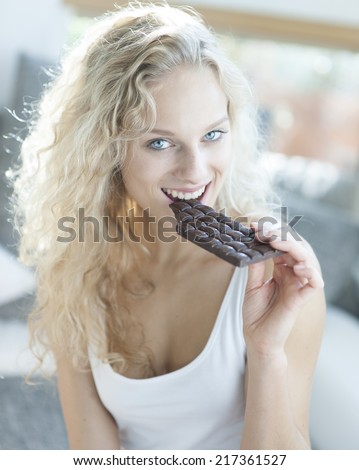 Portrait of sensuous woman eating candy bar