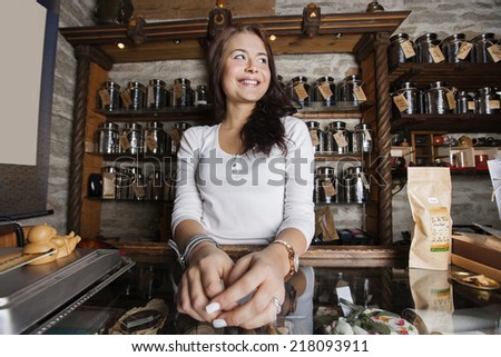 Young female owner looking away in tea store