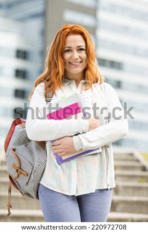 Portrait of beautiful student with textbooks at college campus