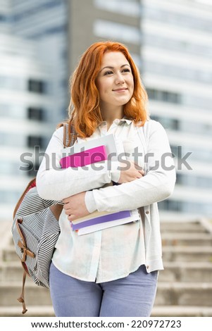 Beautiful young woman with textbooks at college campus