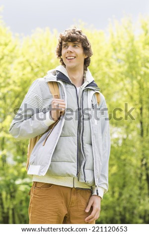 Young man with backpack standing at college campus