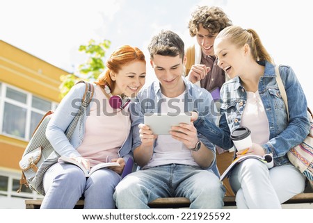 Young students using digital tablet at college campus
