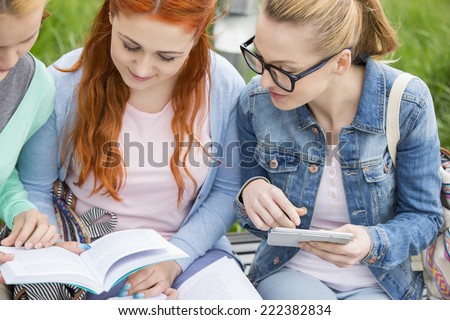 Young women studying together in park