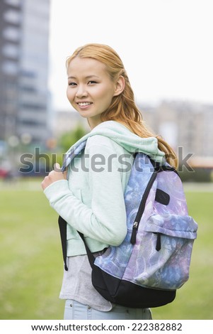 Portrait of happy young woman with backpack at college campus
