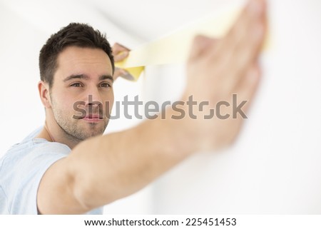 Man applying duct tape on wall