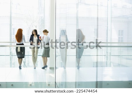 Businesswomen conversing at office hallway