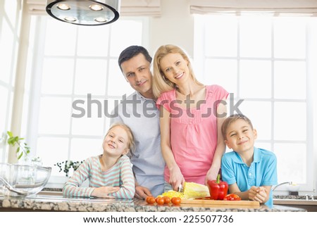 Portrait of happy family preparing food in kitchen