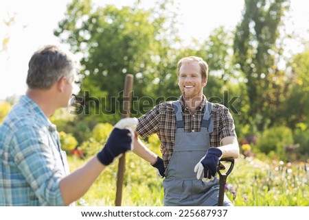 Happy gardeners talking at plant nursery
