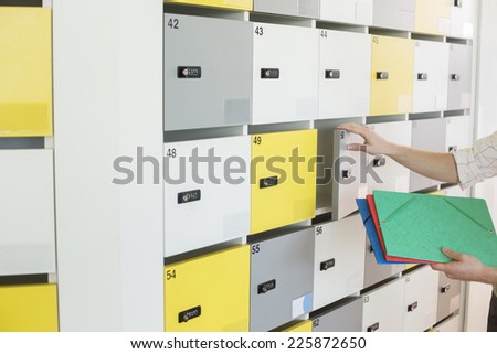 Cropped image of businessman putting files in locker at creative office