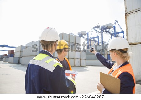 Female supervisor discussing with workers in shipping yard