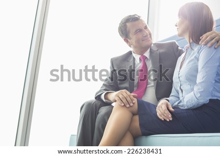 Mature businessman flirting with female colleague in office