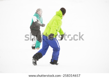 Full length of friends having snowball fight