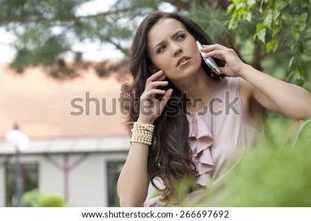 Beautiful young woman using cell phone in park