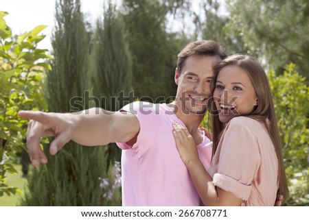 Smiling young man showing something to woman in park