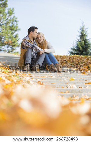 Full length of couple sitting on steps in park