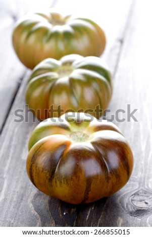 Black tomatoes on wooden table