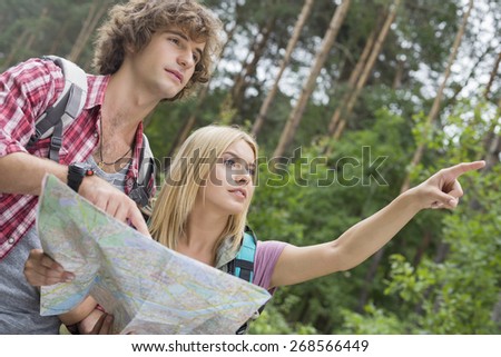 Hiking couple with map discussing over direction in forest