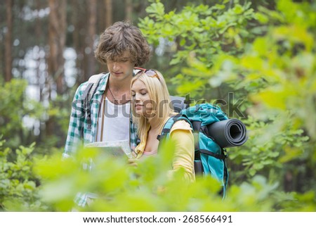 Hiking couple reading map together in forest