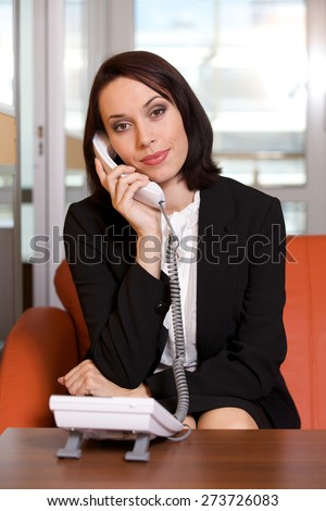 Businesswoman conversing on landline phone, portrait
