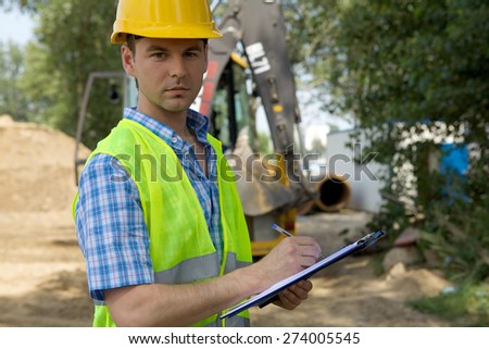 Portrait of architect using clipboard at construction site