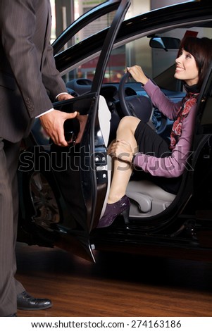 Car salesman giving the car keys to a young woman
