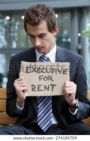 young caucasian businessman in park with executive for rent sign