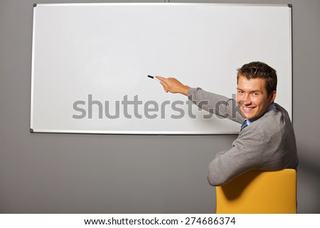 Portrait of businessman pointing at whiteboard in office