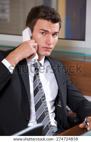 Businessman conversing on landline phone