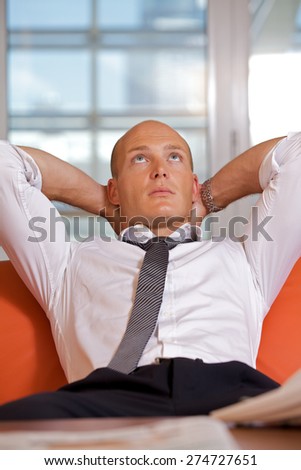 Businessman with hands behind head