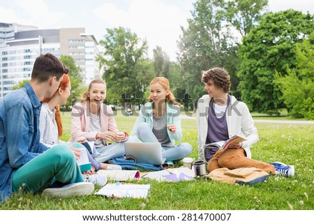 University friends studying together on grass