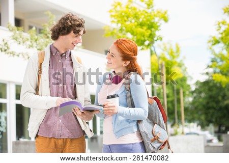Happy young man and woman studying together at college campus