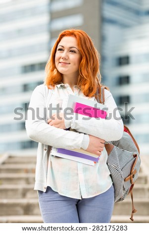Beautiful young woman with textbooks at college campus
