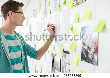 Creative businessman writing on paper in office